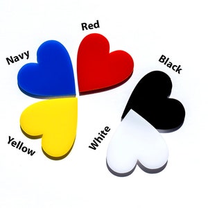 May include: Five heart-shaped pieces of acrylic in different colours: red, navy blue, yellow, white, and black. Each heart has the colour name written above it.