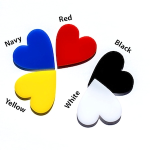 May include: Five heart-shaped pieces of acrylic in different colors: red, navy blue, yellow, white, and black. Each heart has the color name written above it.