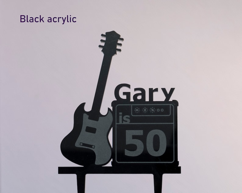 May include: Black acrylic cake topper featuring a silhouette of a guitar and amplifier with the text "Gary is 50".