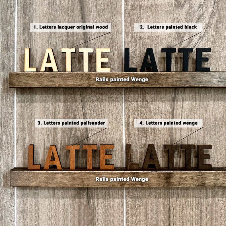 Op de afbeelding: Vier variaties van het woord "LATTE" gespeld in houten letters. De letters worden weergegeven op twee planken met donkerbruine houten rails. De bovenste plank heeft het woord "LATTE" in naturel hout, zwart geverfd, en de onderste plank heeft het woord "LATTE" in geverfd palissander en geverfd weng&eacute;.