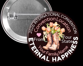May include: A round button with a pin back. The button has a dark brown background with the text "2026 International Convention Location" and "Eternal Happiness". It features a pair of cowboy boots with flowers and a pink heart.