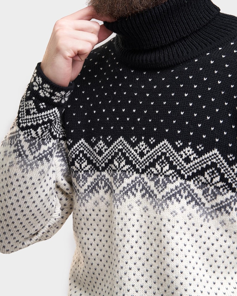 Peut inclure: Un pull &agrave; col roul&eacute; noir et blanc &agrave; motifs. Le pull a un col roul&eacute; noir et un motif blanc et gris sur la moiti&eacute; inf&eacute;rieure.