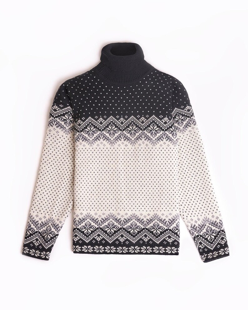Peut inclure: Un pull &agrave; col roul&eacute; noir et blanc &agrave; motif jacquard. Le pull a un col roul&eacute; noir et un fond blanc avec des motifs g&eacute;om&eacute;triques noirs et gris.