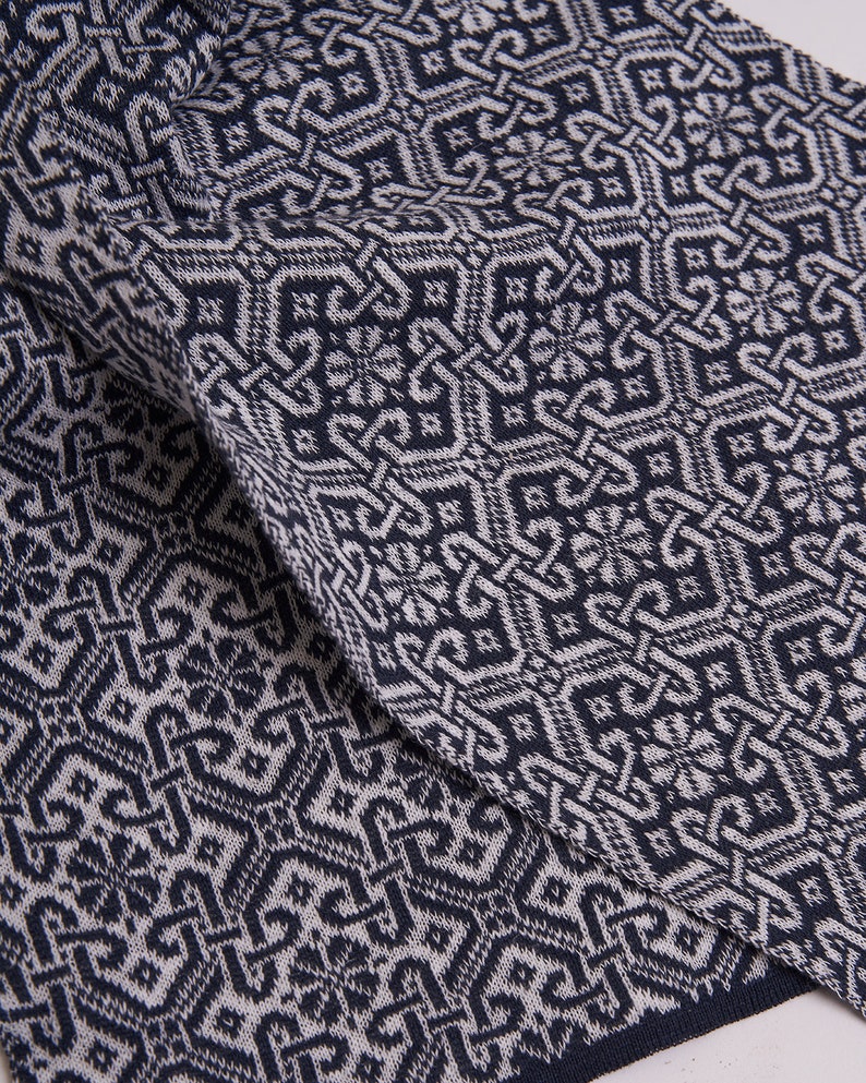 Puede incluir: Primer plano de una tela de punto con estampado azul y blanco. La tela tiene un dise&ntilde;o geom&eacute;trico con formas repetidas.