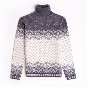 Peut inclure: Un pull &agrave; col roul&eacute; gris et blanc &agrave; motifs avec un design en jacquard.