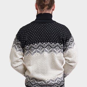 Peut inclure: Pull-over &agrave; col roul&eacute; noir et blanc &agrave; motifs. Le pull est noir sur le haut et blanc sur le bas avec un motif noir et gris.