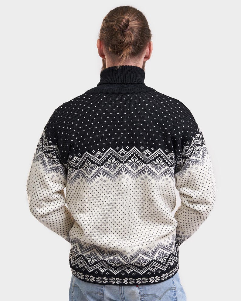 Peut inclure: Pull-over &agrave; col roul&eacute; noir et blanc &agrave; motifs. Le pull est noir sur le haut et blanc sur le bas avec un motif noir et gris.