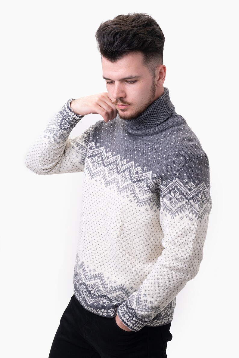 Peut inclure: Un pull &agrave; col roul&eacute; gris et blanc &agrave; motif nordique. Le pull est en tissu tricot&eacute; doux.