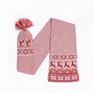 May include: A red and white knitted scarf with a matching hat. The scarf and hat feature a repeating pattern of reindeer and snowflakes. The hat has a red tassel. The scarf is approximately 60 inches long.