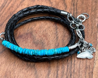 May include: A black leather wrap bracelet with a turquoise bead accent and a silver butterfly charm.