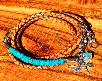 May include: A brown leather braided bracelet with a turquoise stone accent and a silver dragonfly charm.