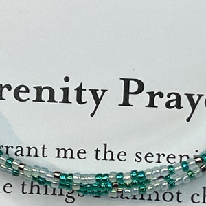 May include: A green and white beaded bracelet with the Serenity Prayer text: "Grant me the serenity to accept the things I cannot change, courage to change the things I can, and wisdom to know the difference."