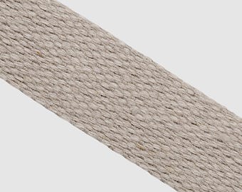 May include: A close-up of a light gray woven cotton webbing strap.