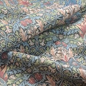 Puede incluir: Primer plano de una tela con un patrón repetitivo de flores y hojas estilizadas en tonos azules, verdes, rosas y rojos sobre un fondo oscuro.