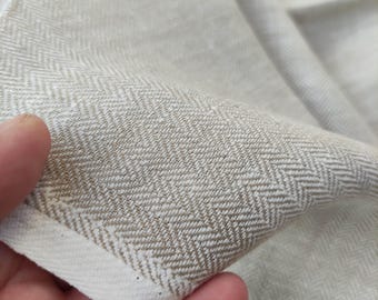 May include: Close-up of a white linen fabric with a subtle herringbone pattern. The fabric is soft and textured, with a slightly rough feel.