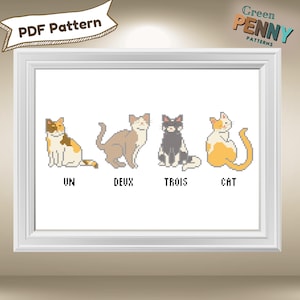 May include: Cross stitch pattern featuring four cats in a row. The cats are in different colors and poses. The pattern is labeled with the French words "Un", "Deux", "Trois", and "Cat".