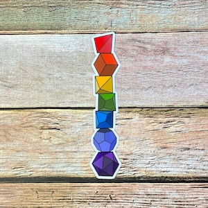 May include: A stack of colorful geometric shapes, resembling dice, in a rainbow pattern. The shapes are red, orange, yellow, green, blue, and purple.