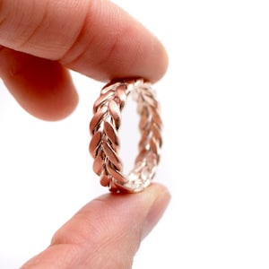 Peut inclure: Une bague tressée en or rose avec une finition lisse et polie.