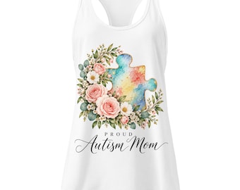Puede incluir: Una camiseta de tirantes blanca con espalda nadadora que presenta un gráfico de pieza de rompecabezas en acuarela rodeado de rosas rosadas, flores blancas y hojas verdes. Debajo, el texto "PROUD Autism Mom" en negro.