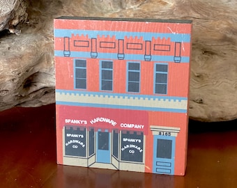 May include: A red, white, and blue wooden model of a hardware store with the name "Spanky's Hardware Company" and the address "$165".