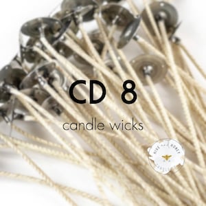 May include: A close-up of a bundle of white cotton candle wicks with metal bases. The text "CD 8 candle wicks" is visible in the image.