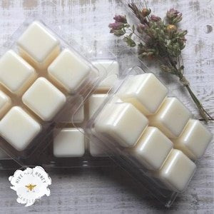 May include: A set of six white wax melts in a clear plastic tray. The wax melts are in the shape of squares. The tray is labeled "Hive and Honey Candles".