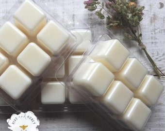 May include: A set of six white wax melts in a clear plastic tray. The wax melts are in the shape of squares. The tray is labeled "Hive and Honey Candles".