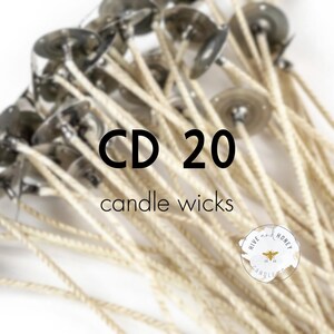 May include: A close-up of a pile of 20 white cotton candle wicks with metal bases. The wicks are bundled together and the metal bases are visible. The text "CD 20 candle wicks" is printed in black on a white background.