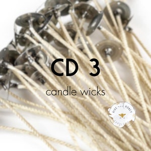 May include: A close-up of a bundle of white cotton candle wicks with metal bases. The wicks are labeled "CD 3 candle wicks".