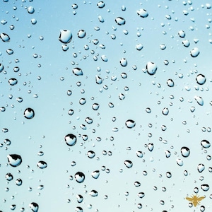 Puede incluir: Una imagen de primer plano de gotas de agua sobre una superficie azul. Las gotas son redondas y transparentes, y están dispersas aleatoriamente sobre la superficie.