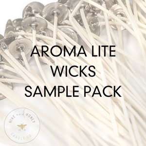 May include: A close-up of a sample pack of Aroma Lite wicks for candle making. The wicks are white and have metal bases. The pack is labeled "Aroma Lite Wicks Sample Pack" and features a logo for Hive and Honey Candle Co.