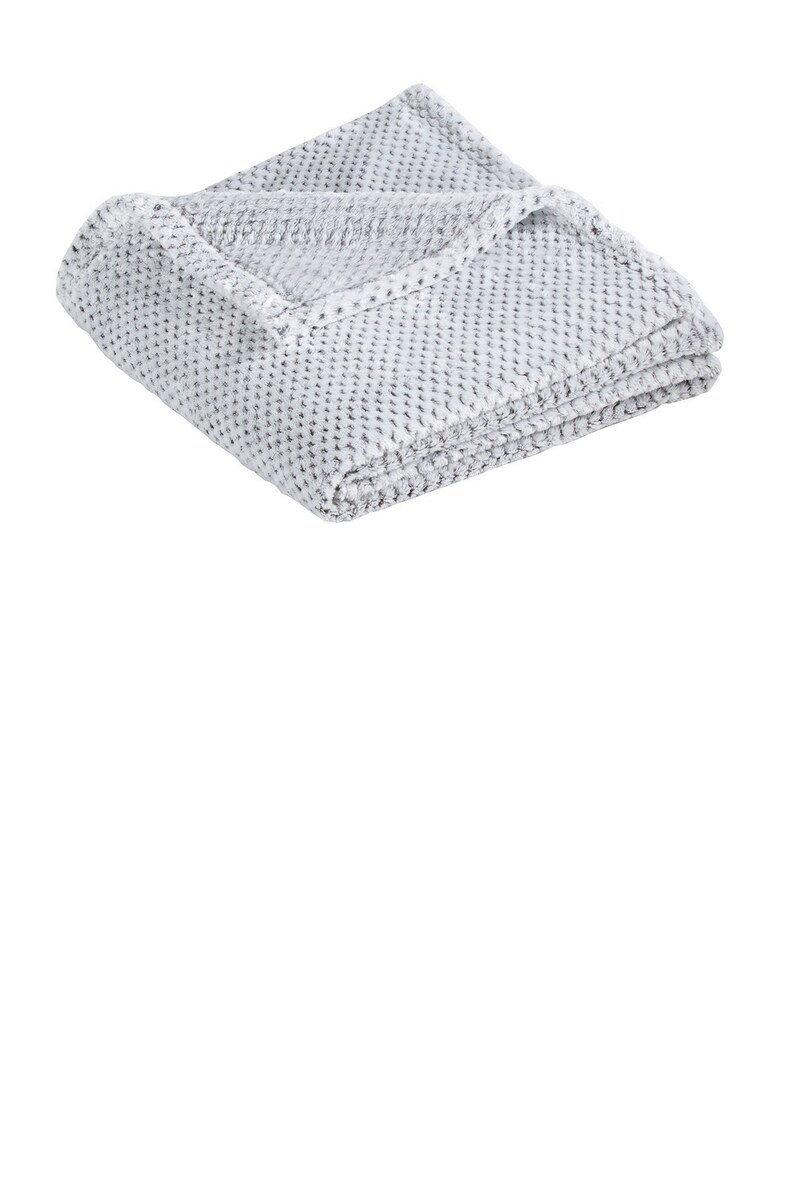 a white blanket sitting on top of a white wall