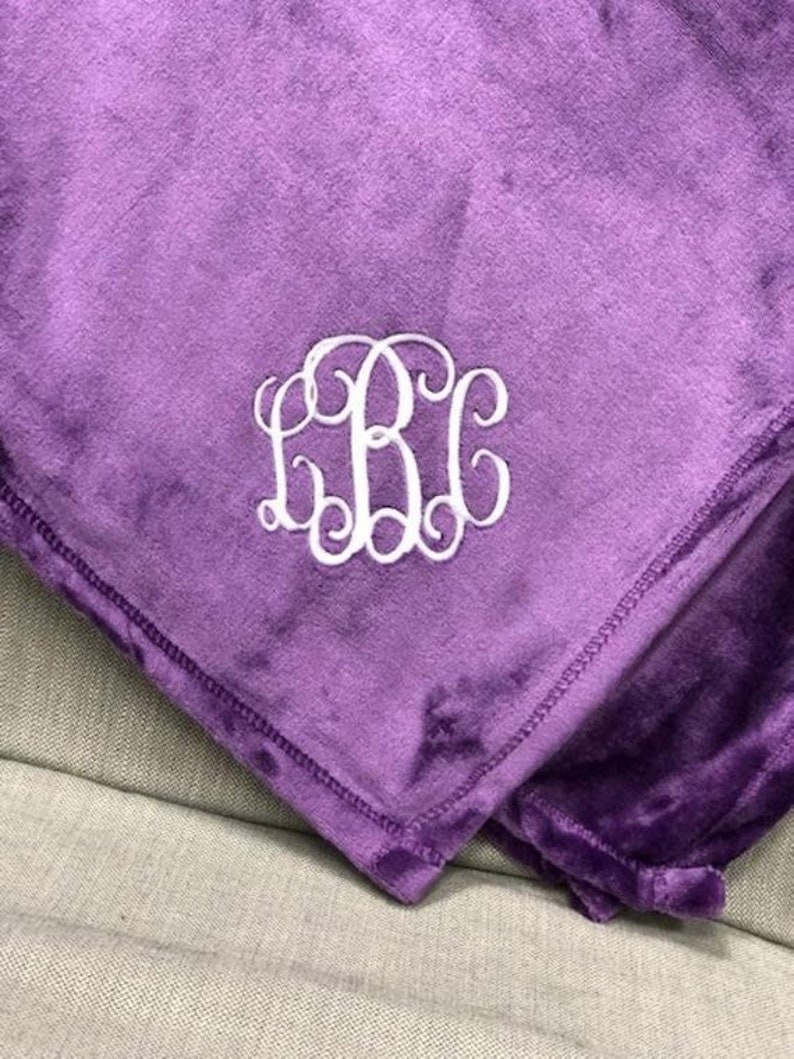 a purple blanket with a monogrammed mono on it