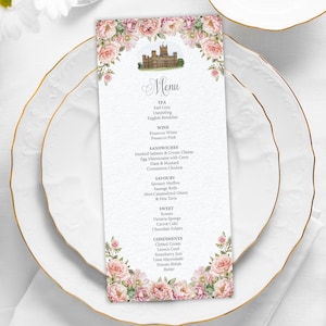 Peut inclure: Un menu imprimé avec un motif floral et une illustration de château, posé sur une assiette blanche avec un bord doré. Le menu propose du thé, du vin, des sandwichs, des plats salés et des desserts.