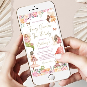May include: A smartphone displays a digital invitation for a "Fairy Garden Tea Party" to celebrate a 5th birthday. The invitation features watercolor illustrations of fairies, flowers, and mushrooms. The text includes the date, time, and location.