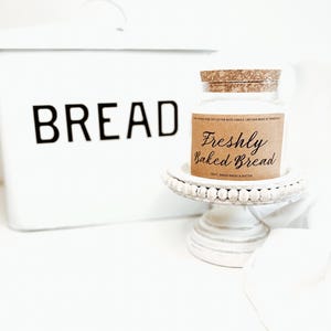 May include: A white ceramic mug with a black handle and the text "But First, Coffee" in a bold, black font. The mug is set against a neutral background, highlighting its simple design.