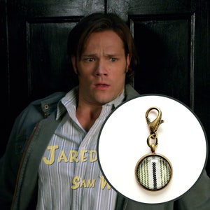 Supernatural Charm “Black & Green Trickster Stripe” Made from Sammy’s Green Trickster Shirt. Bronze.