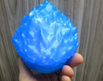 May include: A blue 3D printed sculpture of a flame. The sculpture is made to look like a ball of fire with sharp, jagged edges.