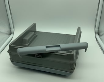 May include: Gray plastic truck bed with a gray plastic tailgate and a gray plastic rear bumper. The truck bed is empty and has a wood-grain texture.