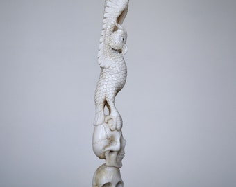 Carved owl statue with 3 skulls