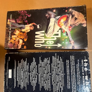 May include: A black box set for The Who's "Thirty Years of Maximum R&B" album. The front of the box features a photo of the band performing live. The back of the box lists the songs included on the album.