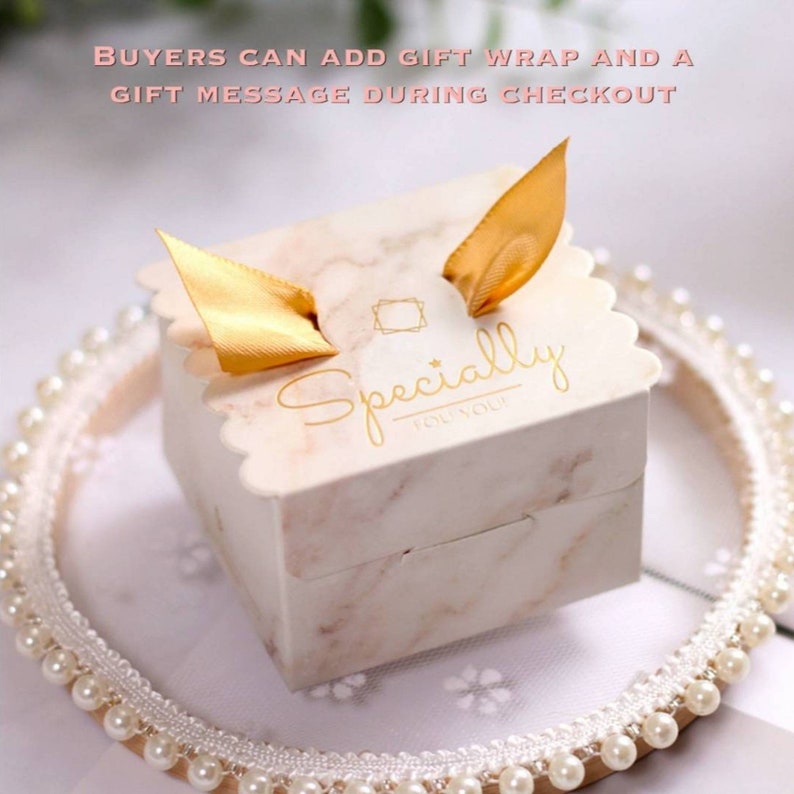 May include: A small white gift box with a marble pattern and gold ribbon. The box has a gold inscription that reads "Specially for you".