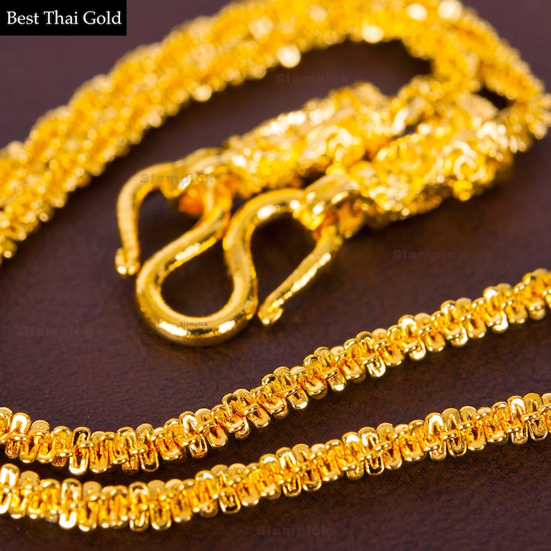 May include: A gold chain necklace with a detailed, intricate design. The chain is made of small, linked circles and has a hook clasp.