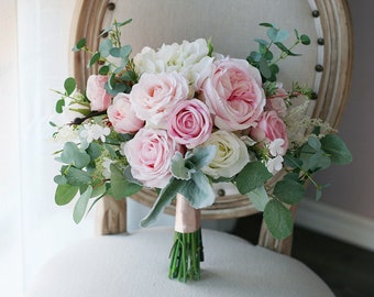 May include: A bridal bouquet with pink and white roses, white hydrangeas, and eucalyptus leaves.