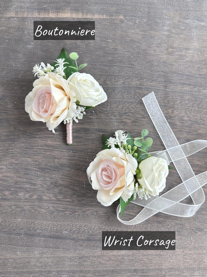 May include: Two white and blush pink rose buttonholes with greenery and white ribbon. The buttonhole on the left is labelled "Boutonniere" and the buttonhole on the right is labelled "Wrist Corsage".