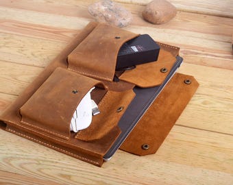 Könnte beinhalten: Eine braune Ledertasche für Laptops mit mehreren Taschen und Fächern. Die Tasche hat einen Klappverschluss und ist aus verwittertem Leder gefertigt.