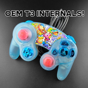 Könnte beinhalten: Ein hellblauer Videospiel-Controller mit einem farbenfrohen Grafikdesign mit Zeichentrickfiguren. Der Controller hat rote und blaue Tasten und der Text "OEM T3 INTERNALS!" wird darüber angezeigt.