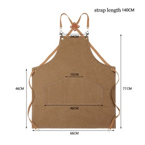 May include: A brown apron with leather straps and a pocket. The apron measures 66cm wide, 77cm long, and has a strap length of 140cm. The pocket is 46cm wide and 15cm high. The apron is designed for kitchen or workshop use.