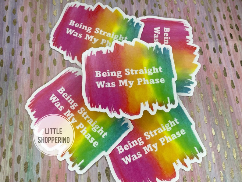May include: Five rainbow-colored stickers with the text "Being Straight Was My Phase" in white. The stickers have a watercolor-like design and are arranged in a pile.