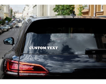 May include: A black car with a white vinyl sticker on the back window that says "CUSTOM TEXT".